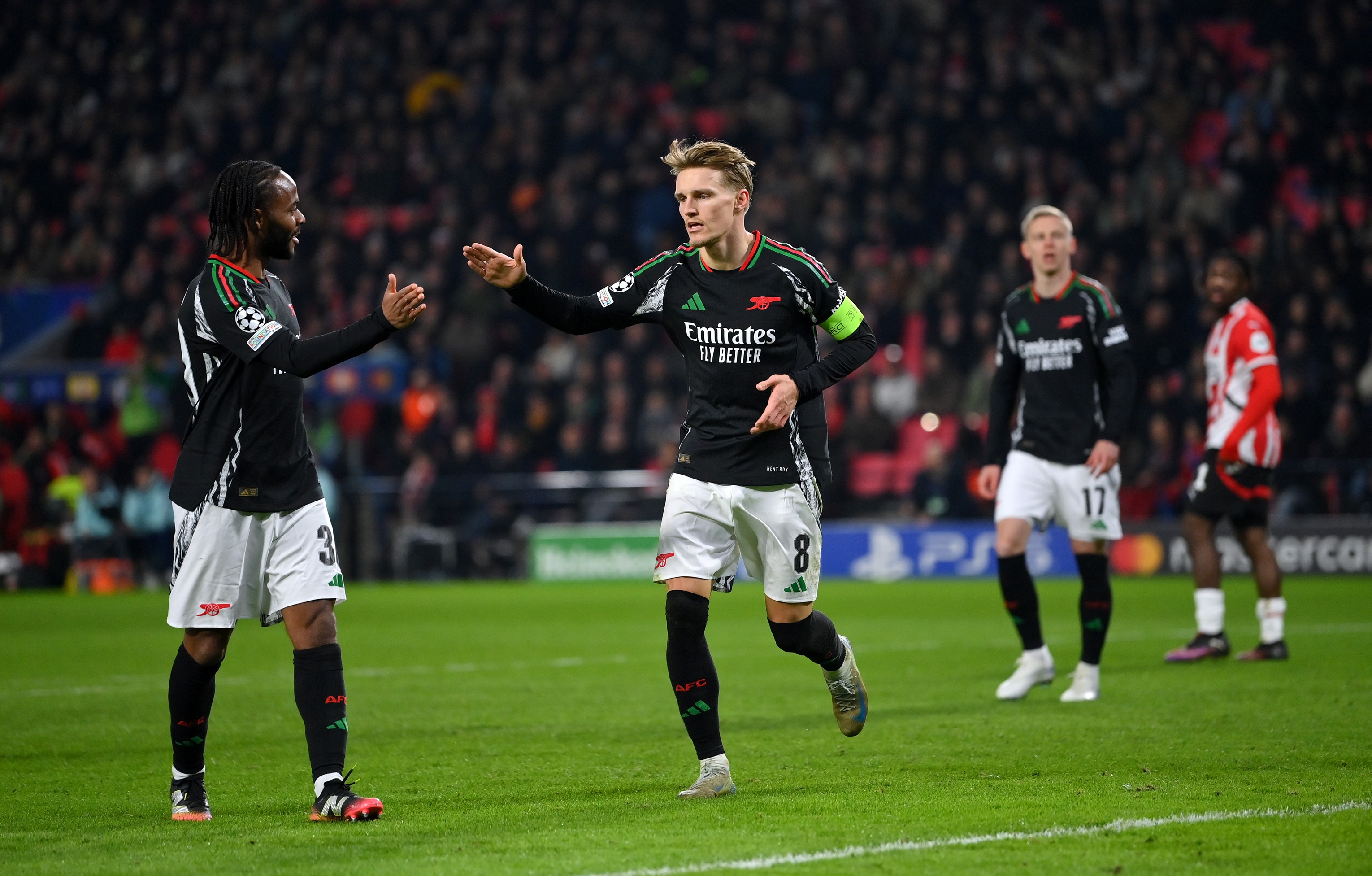 Martin Odegaard High Fives Arsenal teammate Raheem Sterling.