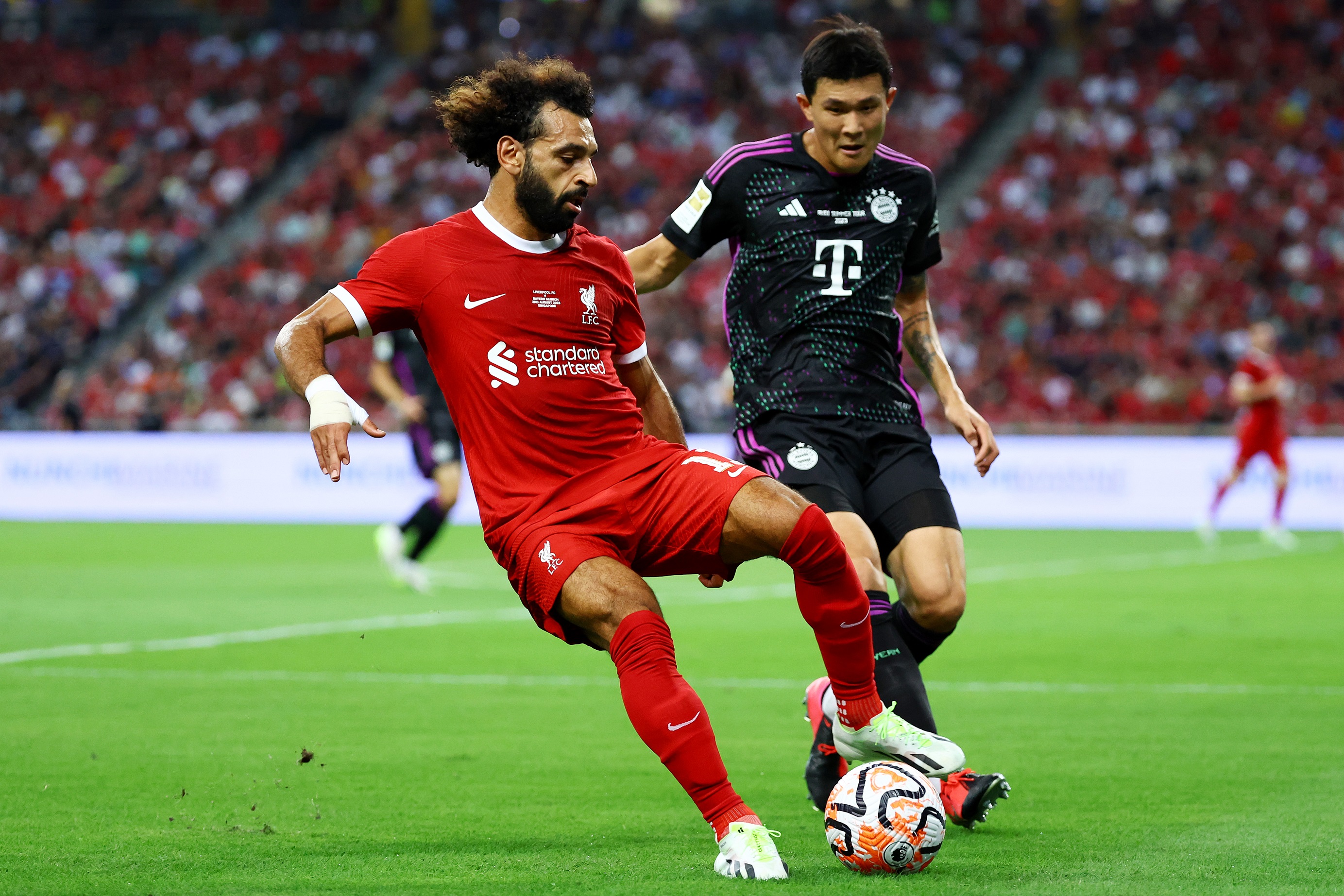 Mo Salah rolls the ball with his boot away from Bayern defender Kim Min-jae.