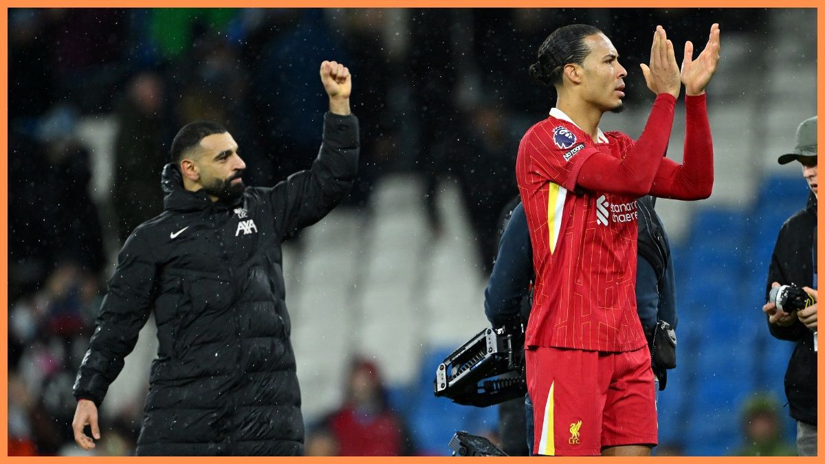 Mo Salah holds his grip in the air while Virgil van Dick clap on Liverpool fans.