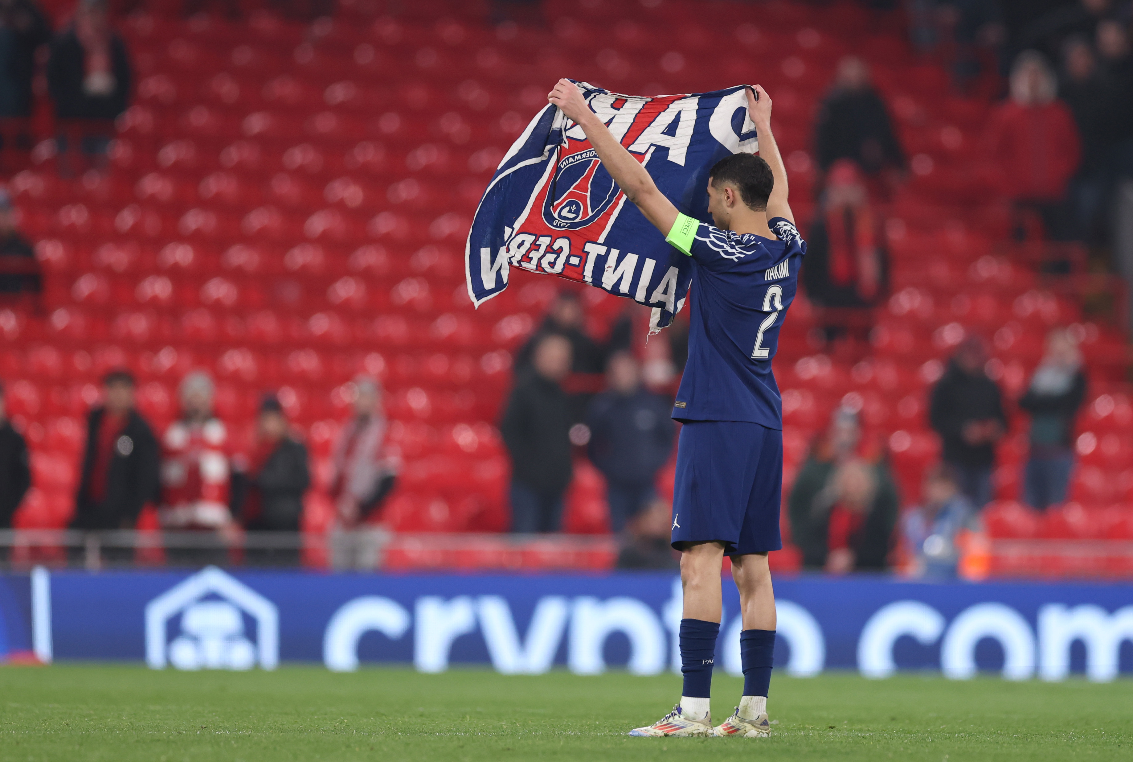 Achraf Hakimi of Paris Saint-Germain celebrates with a flag in Paris Saint-Germain after the team's victory