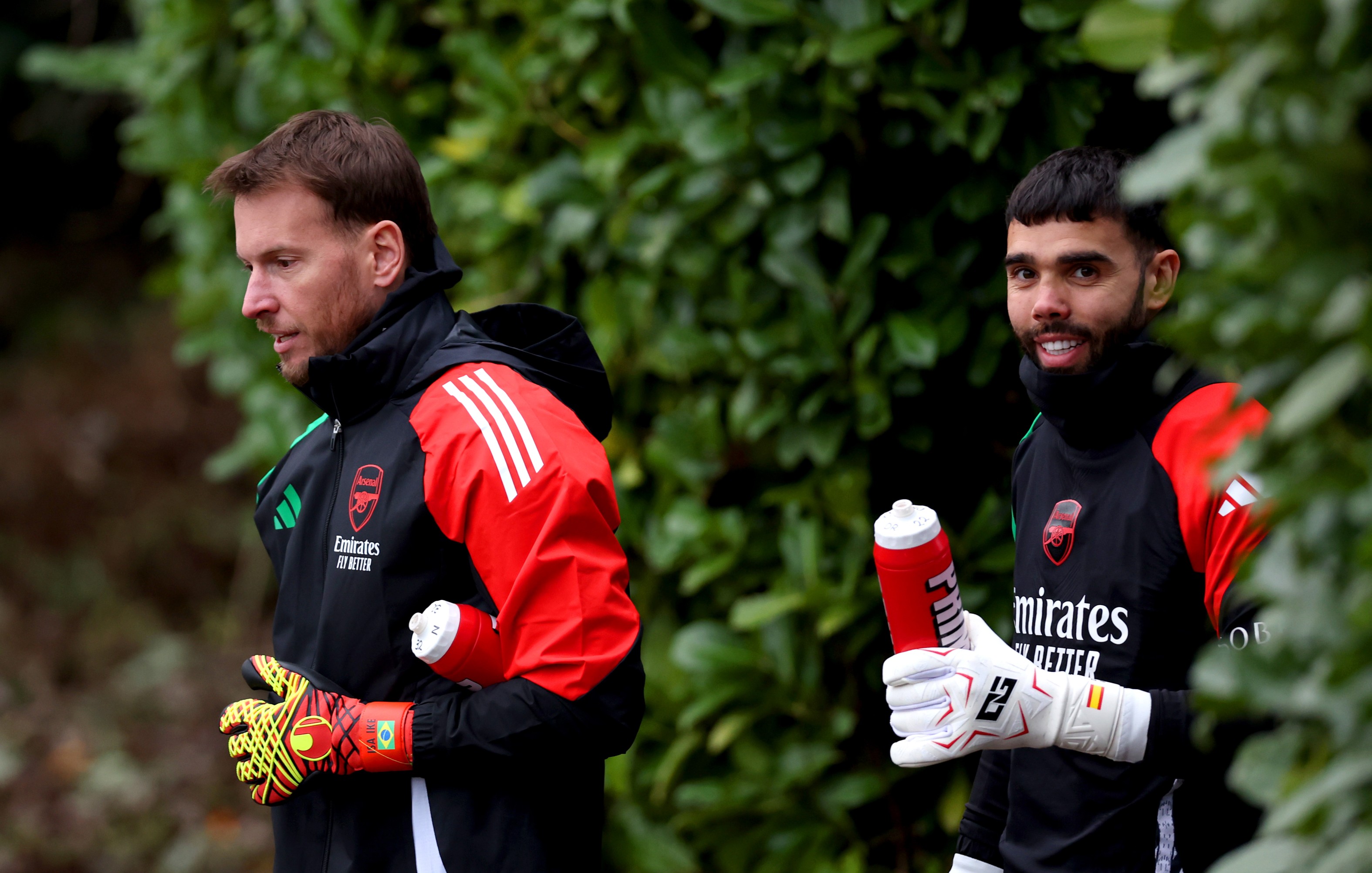 Neto and David Raya of Arsenal make their way out for a training session