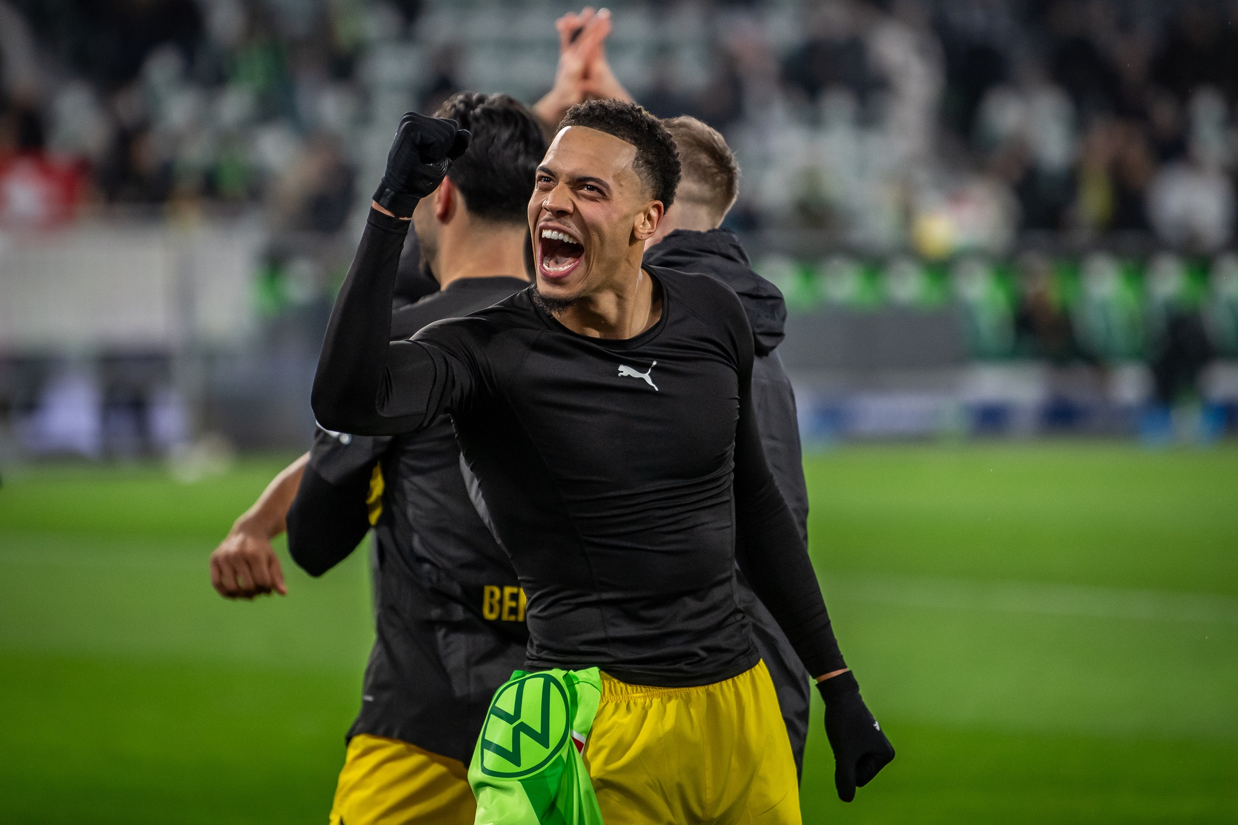 Felix Nmecha salutes Dortmund fans with a raised fist.