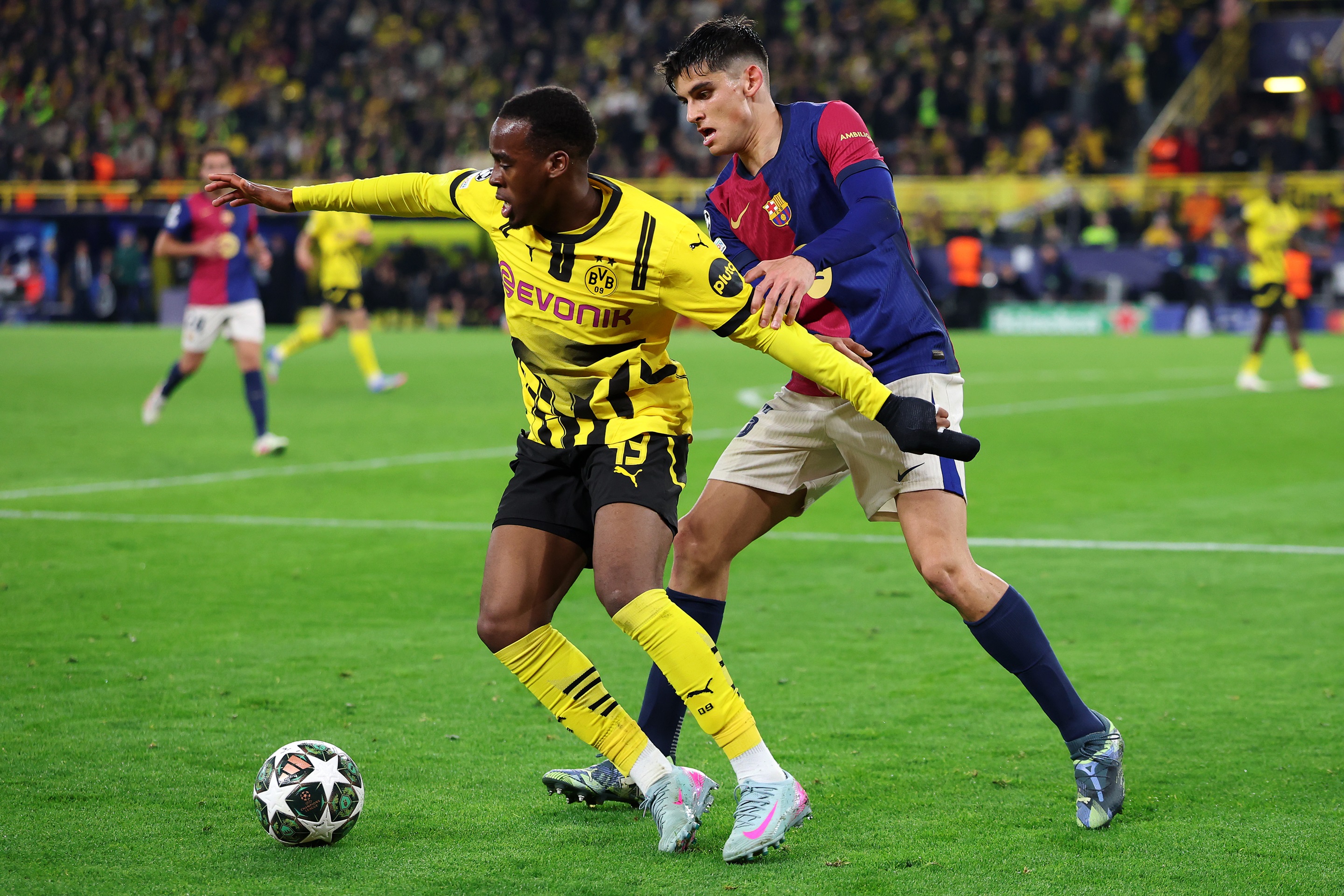 Jamie Gittens holds off Gerard Martin from the ball.