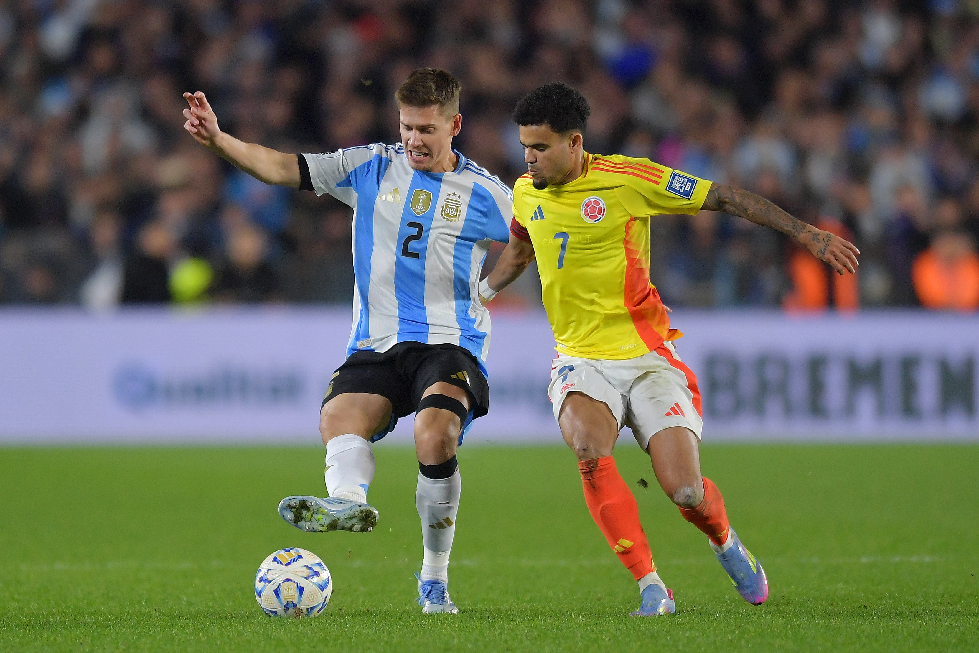 Luis Diaz battles for the ball with the Argentina player.