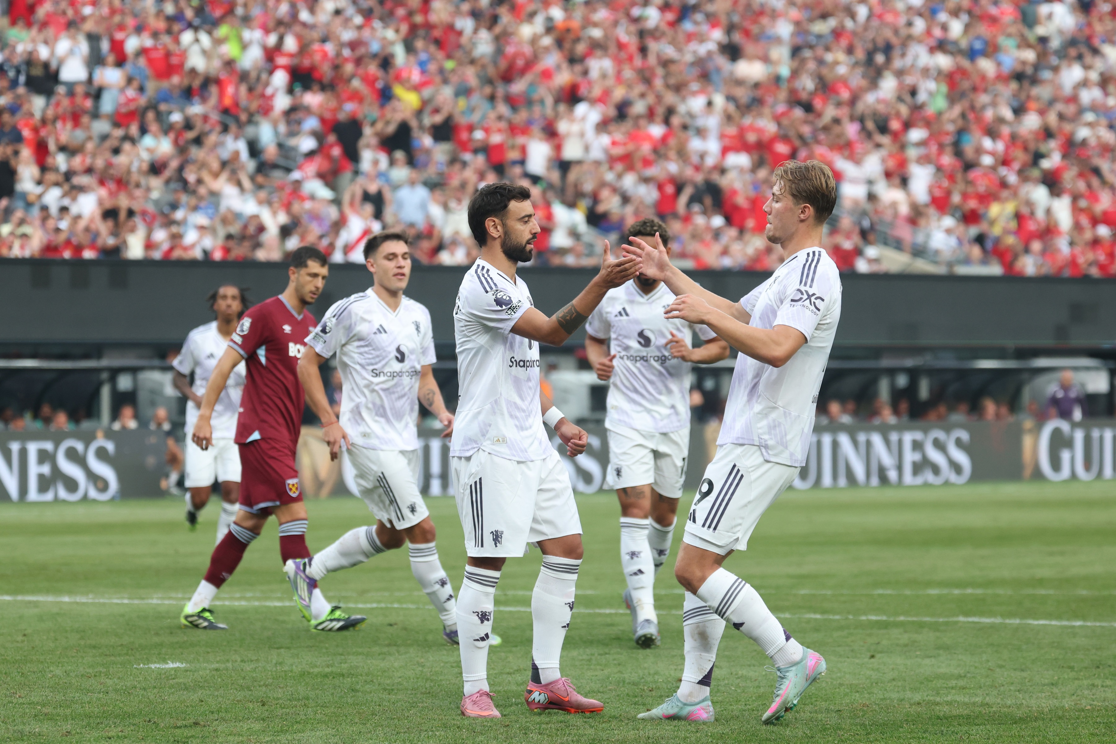 Rasmus Hojlund high fives Bruno Fernandes during Manchester United game.