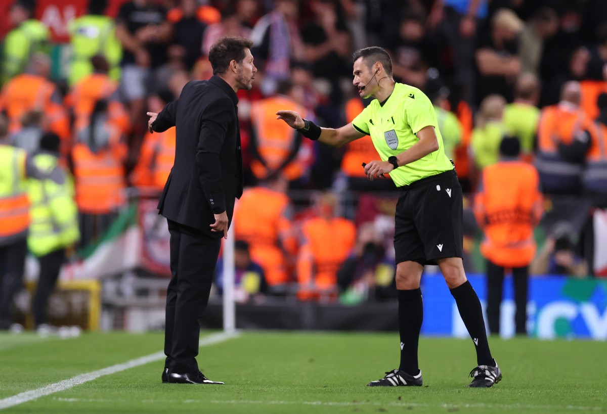 Diego Simeone talks to the referee during Liverpool vs Atletico Madrid