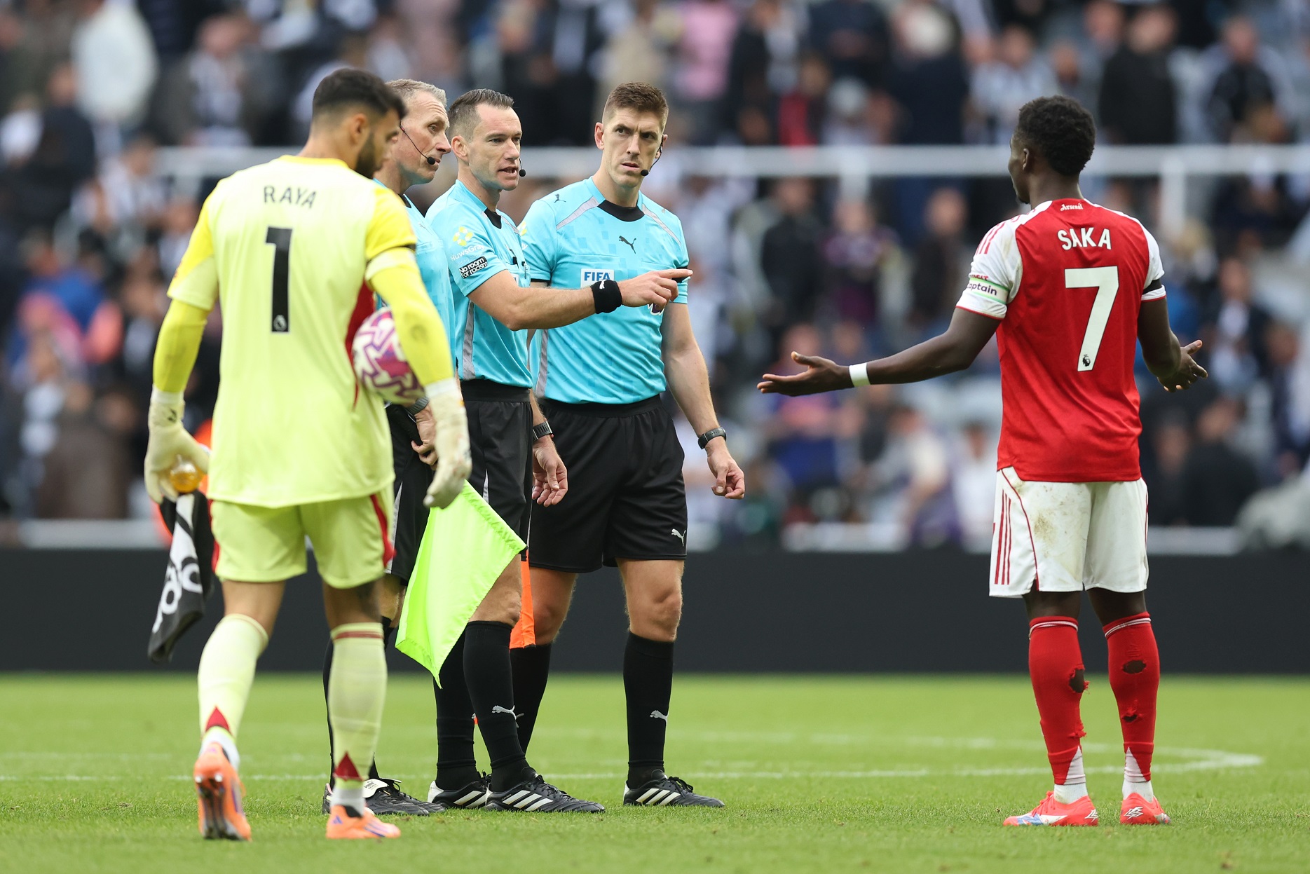 Referee Jarred Gillett speaks with Bukayo Saka of Arsenal at half time 