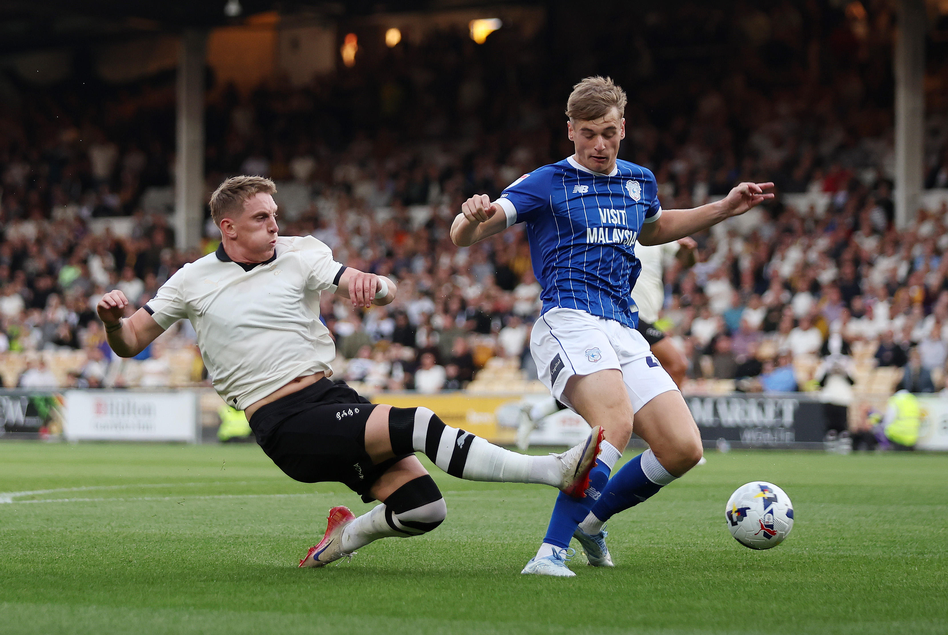 Ronan Curtis of Port Vale takes a shot whilst under pressure from Dylan Lawlor of Cardiff City