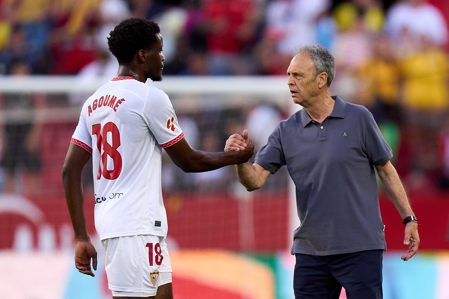 Joaquín Caparros, coach of Sevilla, shakes hands with Lucien Agome