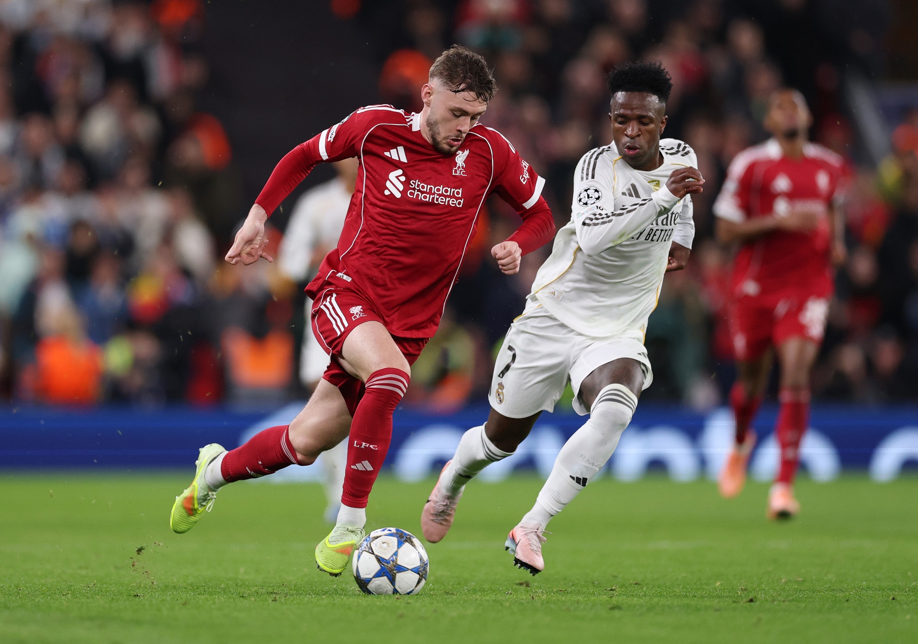 Conor Bradley of Liverpool breaks away from Vinicius Junior of Real Madrid