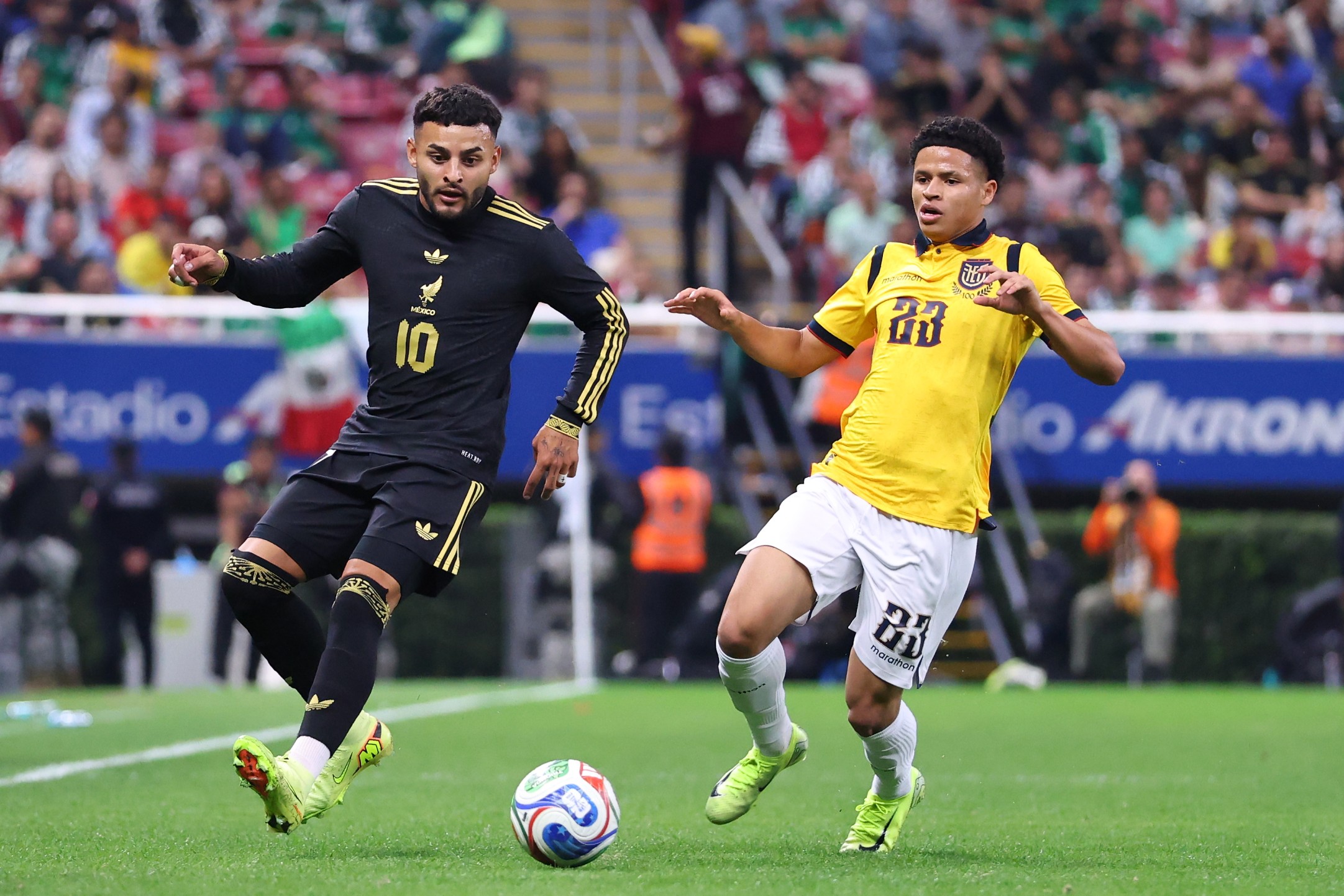 Alexis Vega of Mexico runs with the ball ahead of Patrik Mercado of Ecuador