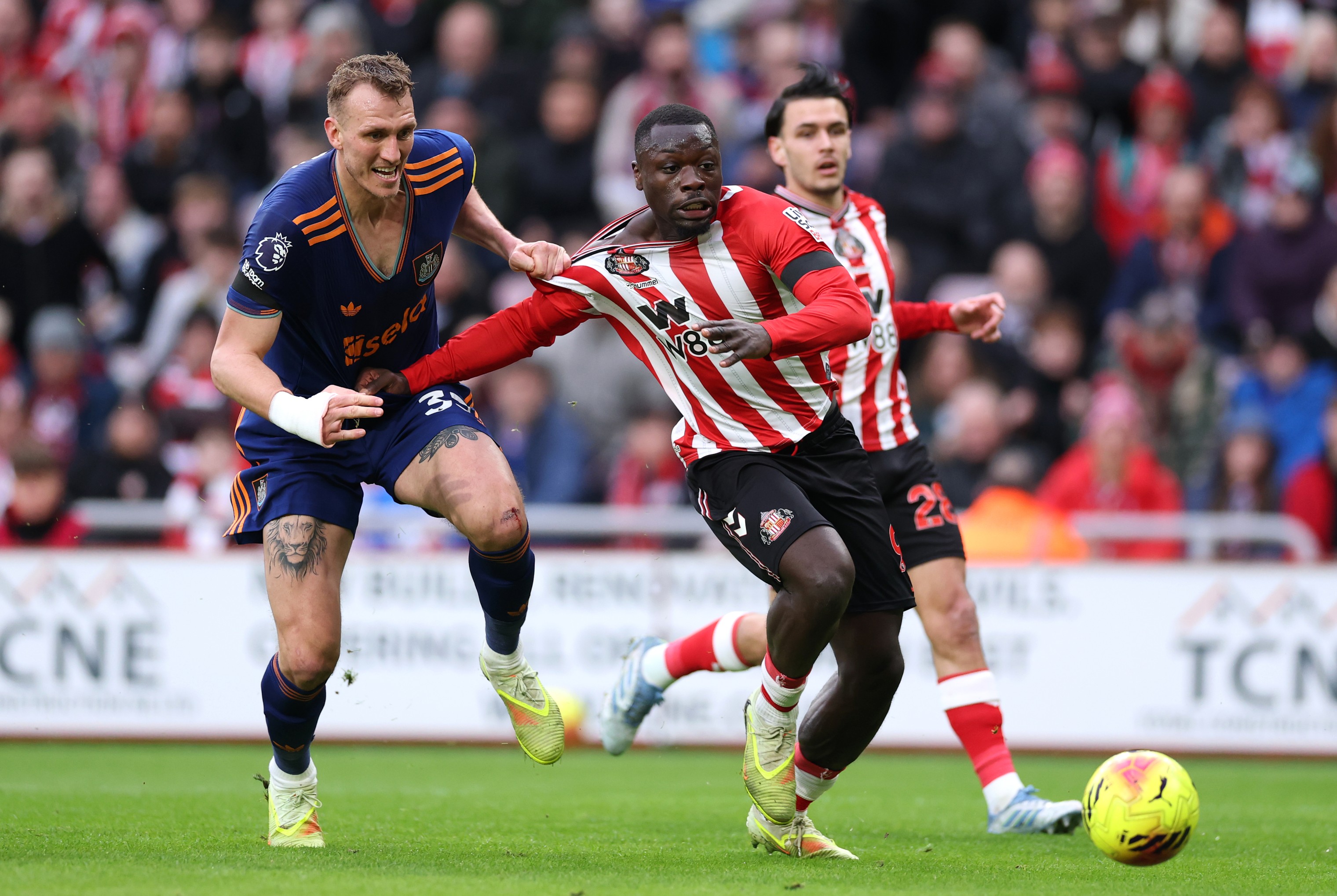 Dan Burn of Newcastle grabs hold of Brian Brobbey of Sunderland
