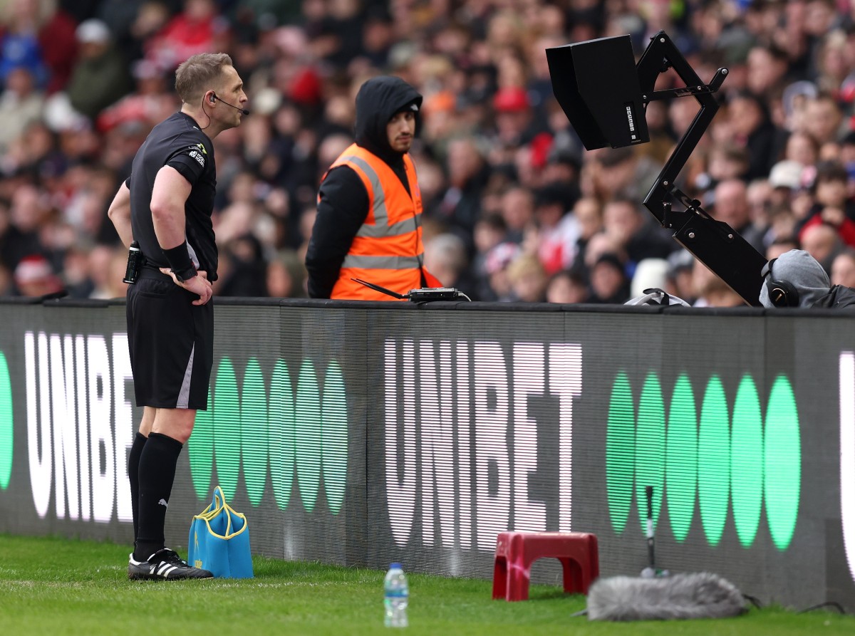 Referee looking at VAR during a Premier League game