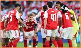 Martin Odegaard speaking in a huddle with his Arsenal teammates